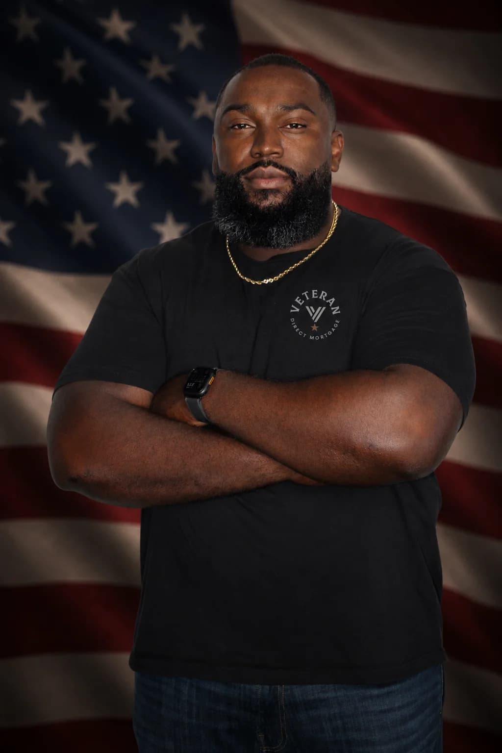 Renaldo Wilson, co-founder of Veterans Direct Mortgages, wearing a branded shirt in front of an American flag